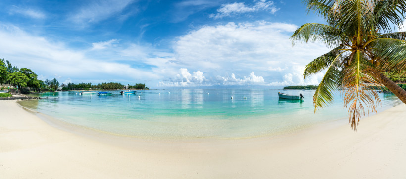 in ruhiger, paradiesischer Strand mit sanften Wellen, schattenspendenden Palmen und glasklarem Wasser – perfekt zum Entspannen und Genießen!