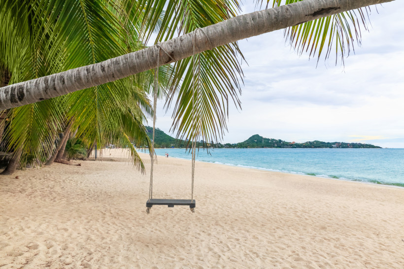 Lamai Beach Koh Samui – Palmenstrand mit Schaukel Idyllischer Palmenstrand am Lamai Beach auf Koh Samui, Thailand, mit Schaukel unter einer Kokospalme und Blick auf das türkisfarbene Meer.