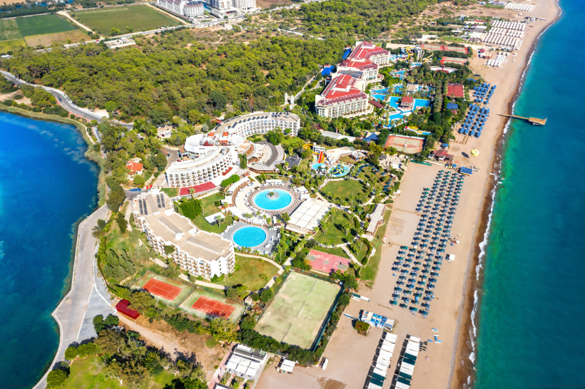 Reisearten in Side an der Türkischen Riviera – Luftaufnahme von Strandhotels, Resorts, Pools und Sportanlagen direkt am Meer