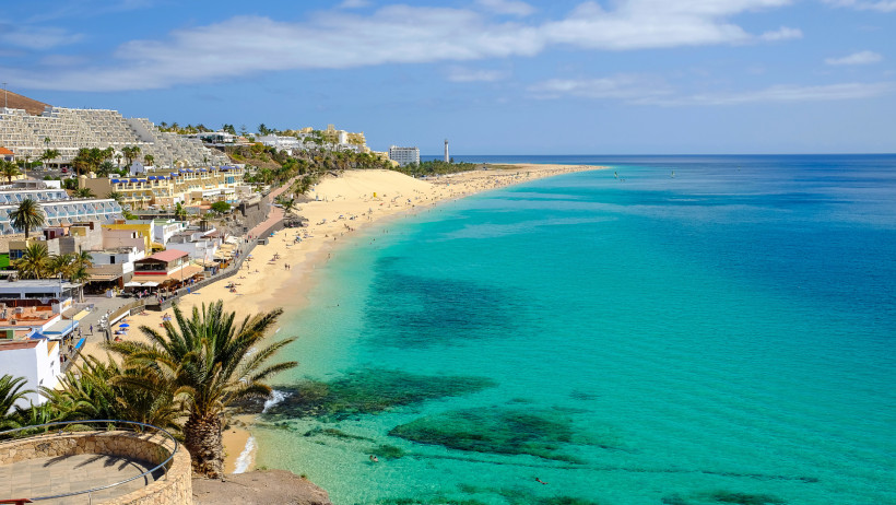 Blick über die Playa del Matorral mit langem Sandstrand, Promenade und türkisfarbenem Meer