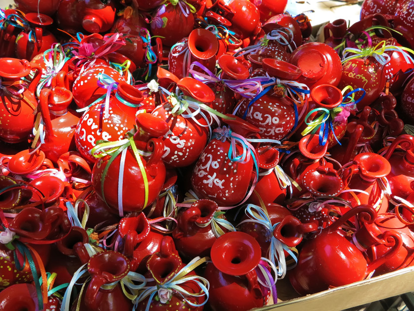  Traditionelles Töpfewerfen zu Ostern auf Korfu: Leuchtend rote Tongefäße mit griechischen Schriftzügen und bunten Bändern sind bereit für das spektakuläre Ritual. Beim „Botides“-Brauchtum werden diese Krüge aus großer Höhe geworfen, um symbolisch das Alt