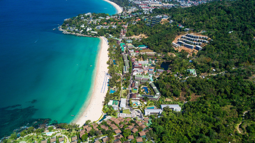 Luftaufnahme von Karon Beach mit langem Sandstrand, türkisfarbenem Meer und Küstenbebauung