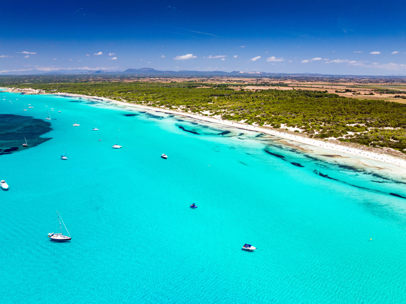 Luftaufnahme der Bucht Es Trenc bei Colonia de Sant Jordi mit türkisfarbenem Wasser, Sandstrand und Segelbooten