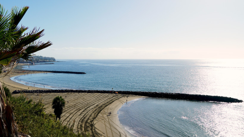 Bucht Playa de las Burras bei San Agustín auf Gran Canaria mit Sandstrand, Wellenbrechern und Blick aufs Meer