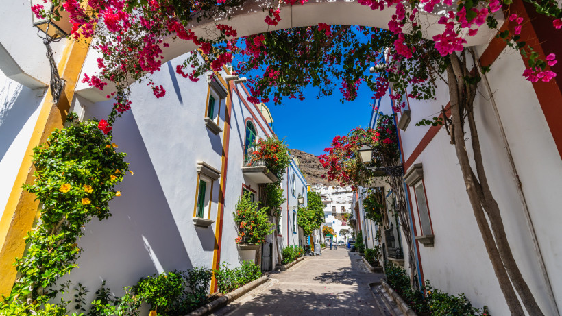 Puerto de Mogán: Gasse mit weiß getünchten Häusern und Bougainvilleen Gasse in Puerto de Mogán mit weiß getünchten Häusern und blühenden Bougainvilleen unter blauem Himmel