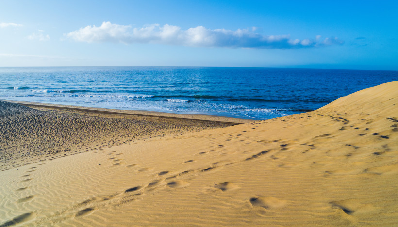 Sanddünen an der Playa de Maspalomas mit Blick auf den Atlantik und eine Wolkenbank am Horizont