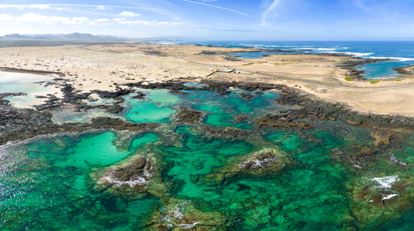 Blick auf die Küste bei La Concha und Los Lagos mit türkisfarbenen Lagunen zwischen dunklem Vulkangestein