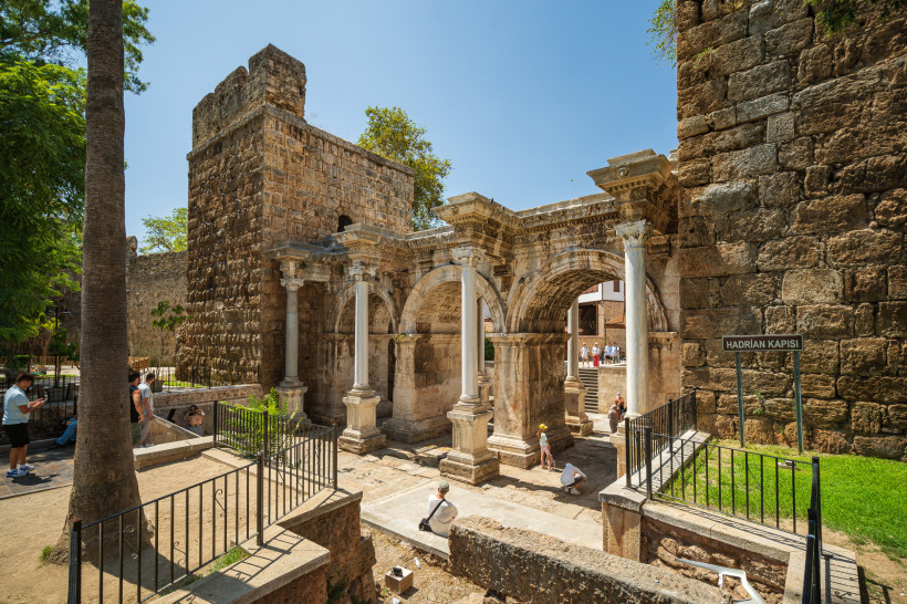 Hadrianstor Antalya – römisches Stadttor an der Grenze zur Altstadt Hadrianstor in Antalya von der Stadtseite mit Besuchern, römische Bögen und historische Mauern am Eingang zur Altstadt Kaleiçi