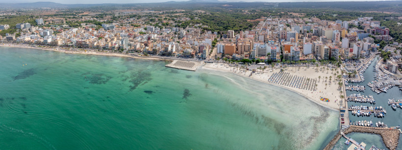 Luftaufnahme der Küstenpromenade und des Sandstrands bei S’Arenal mit Bebauung im Hintergrund