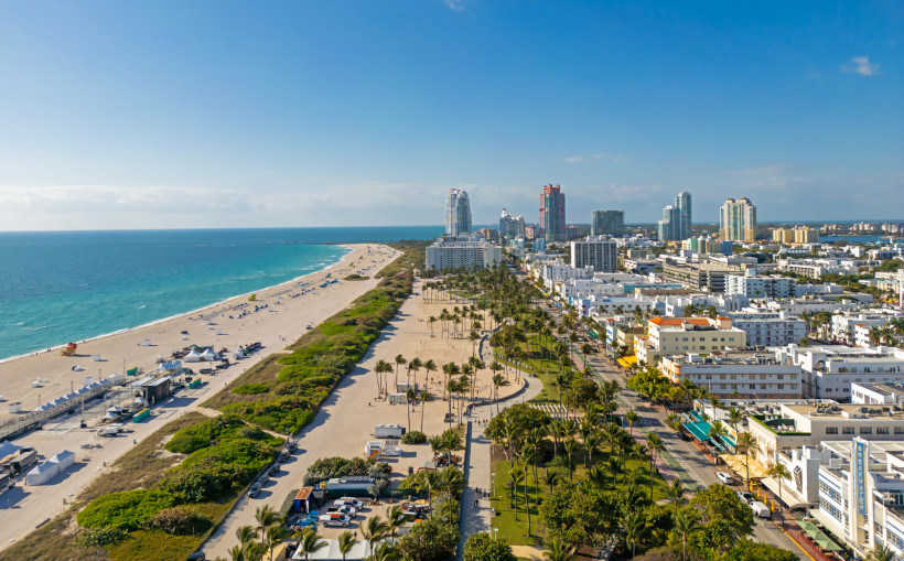 South Beach und Ocean Drive in Miami, Blick über Strand und Küstenbebauung Luftaufnahme von South Beach und Ocean Drive in Miami mit Sandstrand, Palmenpromenade und Hochhäusern im Hintergrund