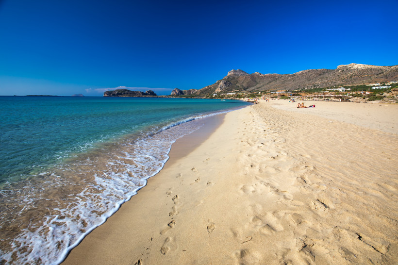 Falassarna Beach: Sandstrand und Küste mit Bergen im Hintergrund Sandstrand von Falassarna Beach mit türkisfarbenem Meer, sanfter Brandung und Bergen im Hintergrund