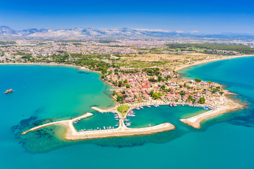 Luftaufnahme der Altstadt von Side mit Hafen, Booten und türkisblauem Meer an der Türkischen Riviera