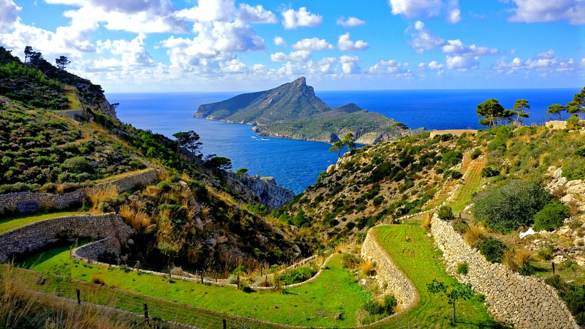 Panoramablick auf Sa Dragonera mit terrassierter Landschaft im Vordergrund und blauem Meer