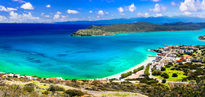 Blick auf die Bucht von Plaka mit türkisblauem Meer, Strand und Küstenort