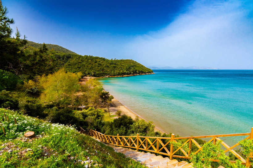 Küstenlandschaft im Nationalpark Dilek mit Sandstrand, türkisfarbenem Meer und bewaldeten Hügeln