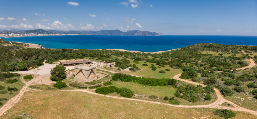 Castell de n’Amer an der Küste mit Blick auf Meer und Bucht, umgeben von Dünen und Vegetation
