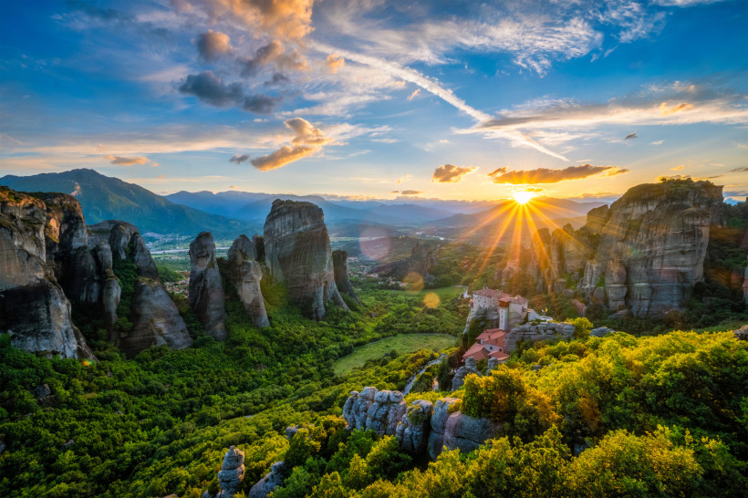 Griechenland - Meteora Sonnenuntergang über den Meteora-Klöstern in Griechenland mit spektakulären Felsformationen und grüner Landschaft