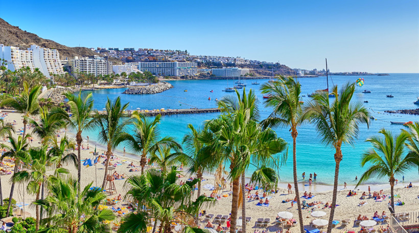 Anfi del Mar auf Gran Canaria – Paradiesischer Strand mit Palmen und kristallklarem Wasser Anfi del Mar Strand auf Gran Canaria – Palmen, weißer Sand und türkisblaues Meer vor modernen Hotels