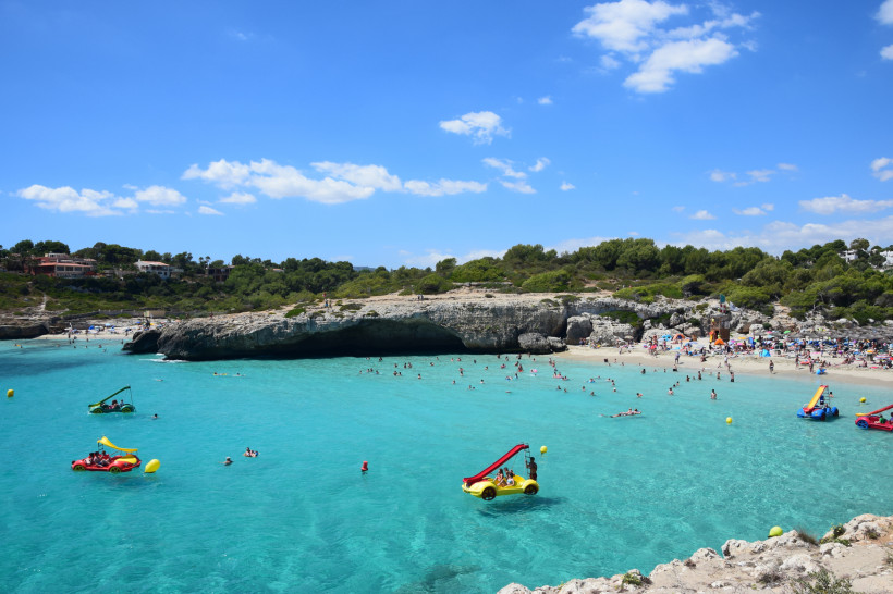 Cala Domingos (breit und familiengeeignet) in Calas de Mallorca mit flachem Einstieg und Tretbooten im türkisfarbenen Wasser