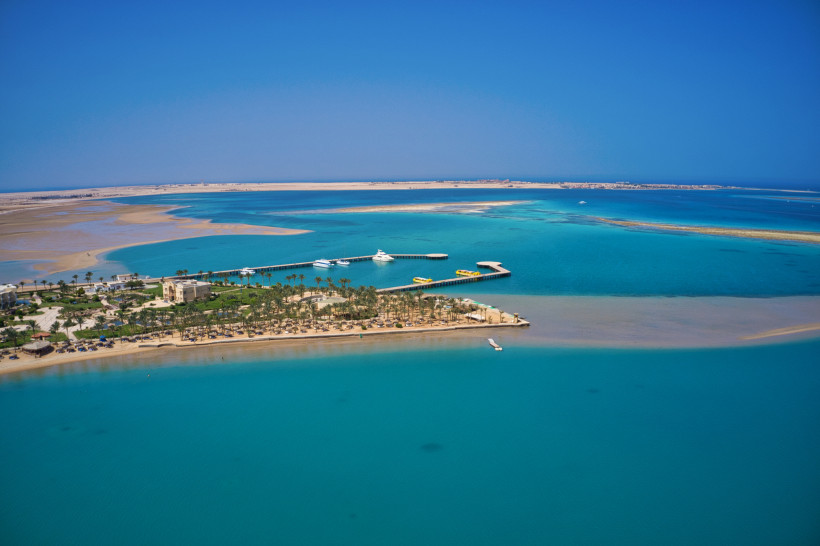 Atemberaubender Blick auf eine türkisfarbene Lagune am Roten Meer Panoramablick auf eine türkisblaue Lagune mit Palmen, Strand und Anlegestegen am Roten Meer