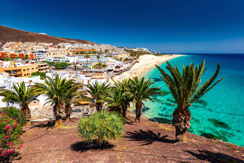 Blick auf die Küste von Morro Jable auf Fuerteventura mit Palmen, Hotels und türkisblauem Meer