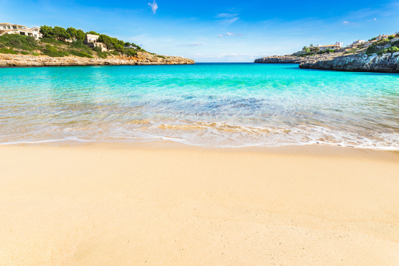 Sandstrand und türkisfarbenes Meer in der Bucht Cala Marçal bei Portocolom