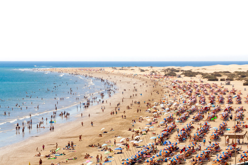 Blick über den Strand Playa del Inglés mit vielen Badegästen, Liegestühlen und Sonnenschirmen am Atlantik