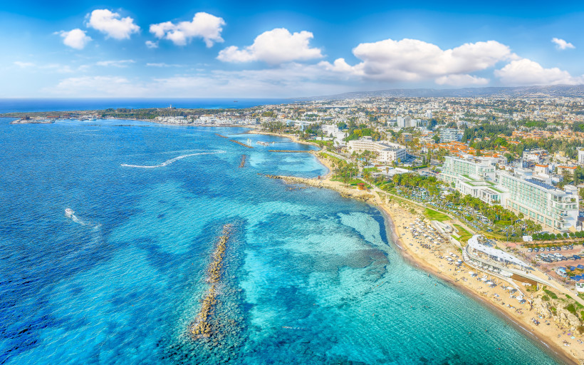 Panoramablick auf Paphos an der Südküste Zyperns mit türkisblauem Meer, Strandabschnitten und Hotels direkt am Wasser.