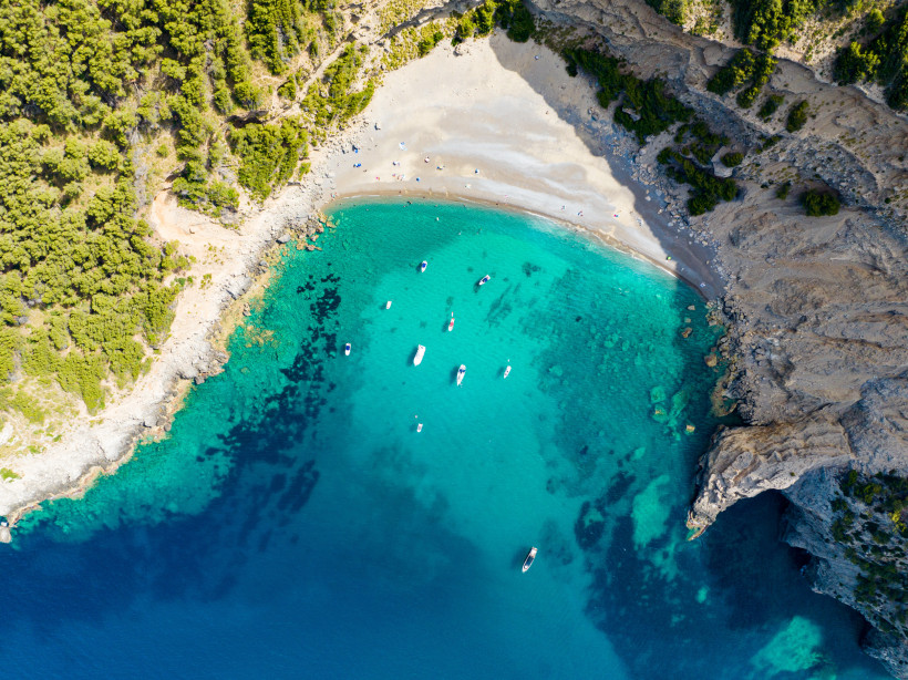 Mallorca - Platja des Coll Baix Luftaufnahme von Platja des Coll Baix, einer abgelegenen Badebucht im Norden Mallorcas. Die sichelförmige Bucht ist von steilen Felsen eingerahmt und nur zu Fuß oder mit dem Boot erreichbar. Der Strand besteht aus hellem Kies und Sand, das Wasser leuchtet