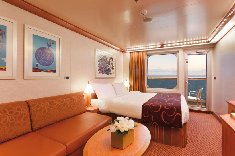 Costa Favolosa: Balkonkabine mit Doppelbett, Sitzbereich und Balkon Balkonkabine auf der Costa Favolosa mit Doppelbett, Sofa und Balkonblick aufs Meer