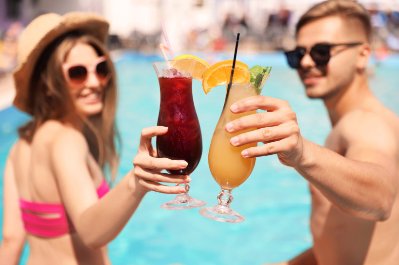 Paar genießt Cocktails am Pool eines All-Inclusive-Hotels – entspannter Urlaub mit Getränkeservice und Sonnengarantie