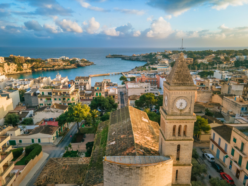 Mallorca - Porto Cristo Luftaufnahme von Porto Cristo auf Mallorca. Im Vordergrund die historische Kirche Església Mare de Déu del Carme mit ihrem markanten Glockenturm und der großen Uhr. Die Kirche ist aus hellem Sandstein erbaut und steht inmitten der Altstadt mit vielen Häus
