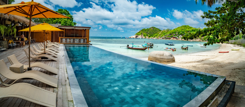 Thailand Strand mit Infinitypool und Longtail-Booten – Urlaub für jedes Budget Infinitypool eines Strandresorts in Thailand mit Blick auf Longtail-Boote und türkisfarbenes Meer – ideale Kombination für günstigen, preiswerten oder luxuriösen Urlaub.