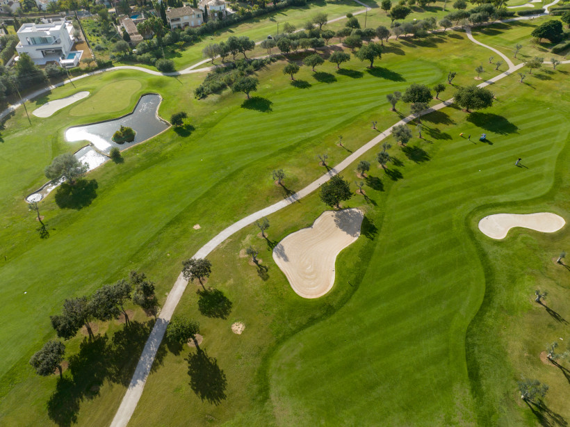 Luftbild des 18-Loch-Golfplatzes Canyamel mit Fairways, Bunkern und Olivenbäumen