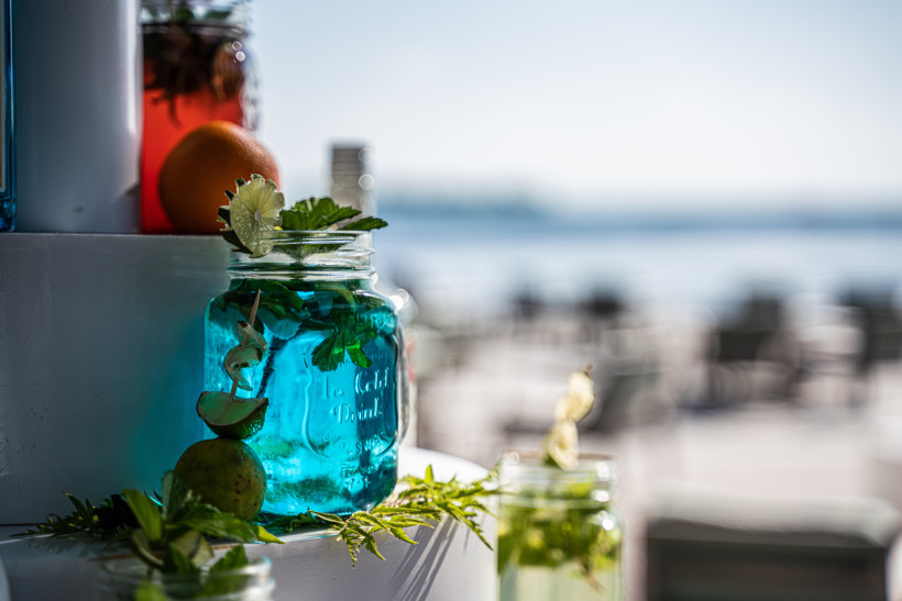 Karibik Cocktail mit Meerblick auf Curaçao Blauer Cocktail im Glas mit Limette und Minze am Strand von Curaçao