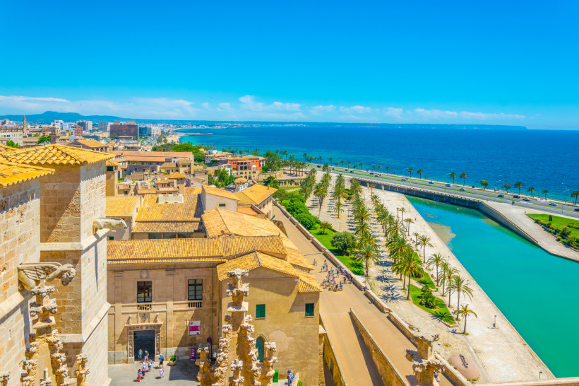 Blick über Palma de Mallorca auf den Parc de la Mar mit Palmenpromenade, Wasserbecken und Küstenstraße am Meer