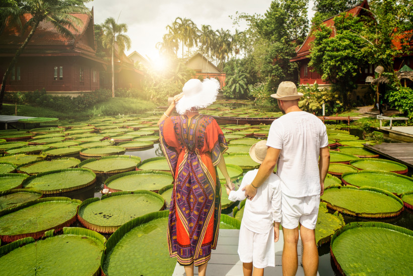 Familie im botanischen Garten mit Riesenseerosen – Thailand Familienurlaub Erlebnis Familie betrachtet riesige Seerosen in einem thailändischen botanischen Garten – tropisches Naturerlebnis für Familien auf Thailandreise.