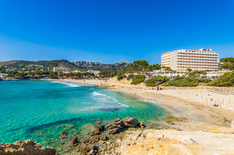 Blick auf den Sandstrand und die Bucht von Paguera mit Hotelgebäude und Küstenlandschaft