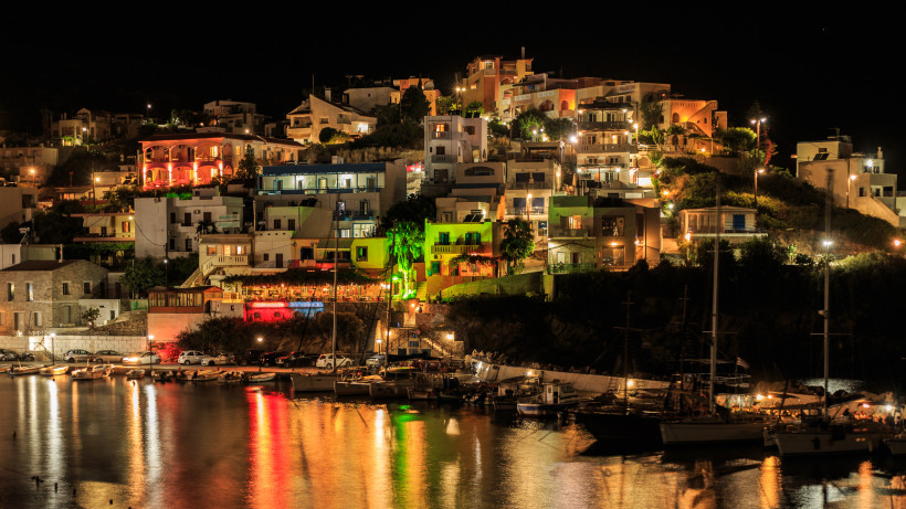 Bali auf Kreta bei Nacht mit beleuchteten Häusern am Hang und Hafen im Vordergrund Nächtliche Uferpromenade und Häuser am Hang in Bali auf Kreta, Lichter spiegeln sich im Hafenwasser
