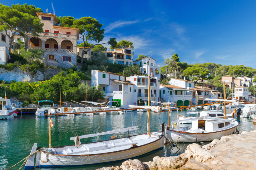 Hafenbucht von Cala Figuera auf Mallorca mit Booten am Steg und weißen Häusern am Ufer