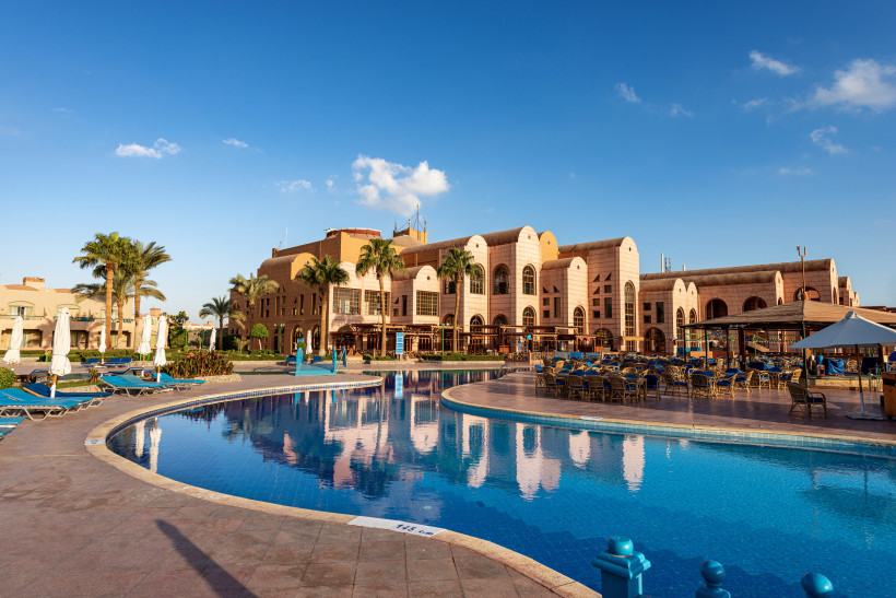 Große Hotelanlage in Marsa Alam mit Pool, Palmen und sonnigem Himmel