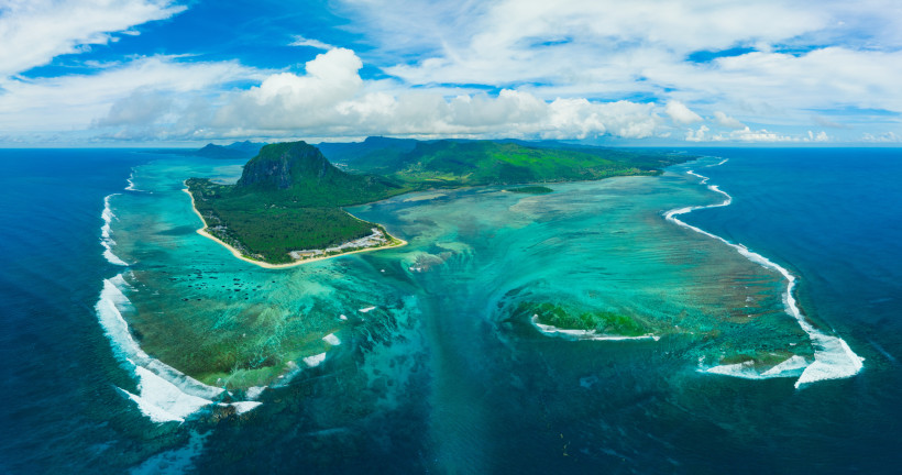 Spektakuläre Luftaufnahme von Le Morne auf Mauritius mit dem berühmten Unterwasser-Wasserfall-Effekt im Indischen Ozean