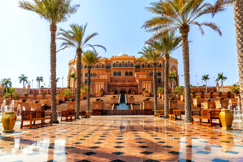 Eingang zum Emirates Palace Hotel in Abu Dhabi mit Palmen, Springbrunnen und prachtvoller Architektur