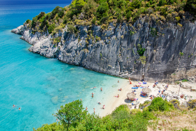 Insel Zakynthos, Griechenland kleiner Strand mit Leuten auf Zakynthos neben einem riesigen Felsen