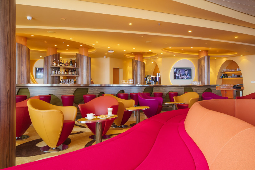 Innenbereich des Cafe Mare auf der AIDAperla mit Bar und farbigen Sitzgruppen