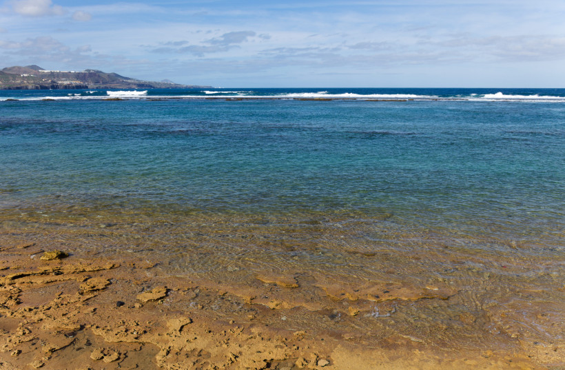 Flacher Küstenabschnitt mit klarem Wasser und Riffkante bei Playa Chica in Las Palmas