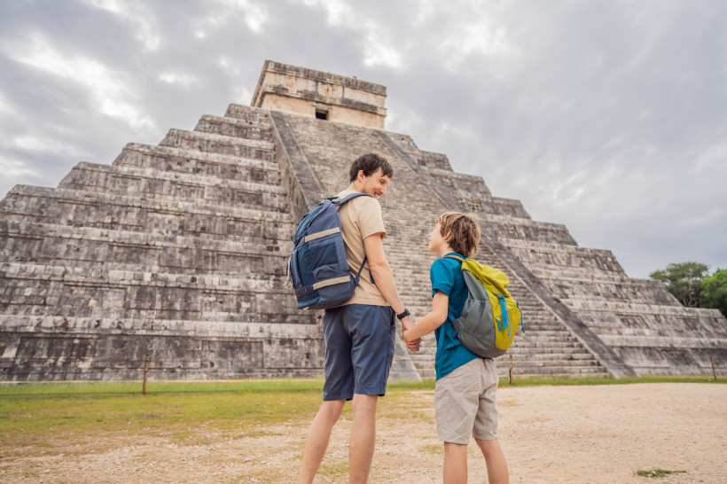 Mexiko Vater und Sohn Touristen beobachten die alte Pyramide und den Tempel der Burg der Maya-Architektur bekannt als Chichen Itza Dies sind die Ruinen dieser alten präkolumbischen Zivilisation