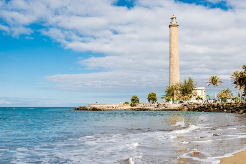 Leuchtturm von Maspalomas an der Küste mit Strand, Wellen und Palmen