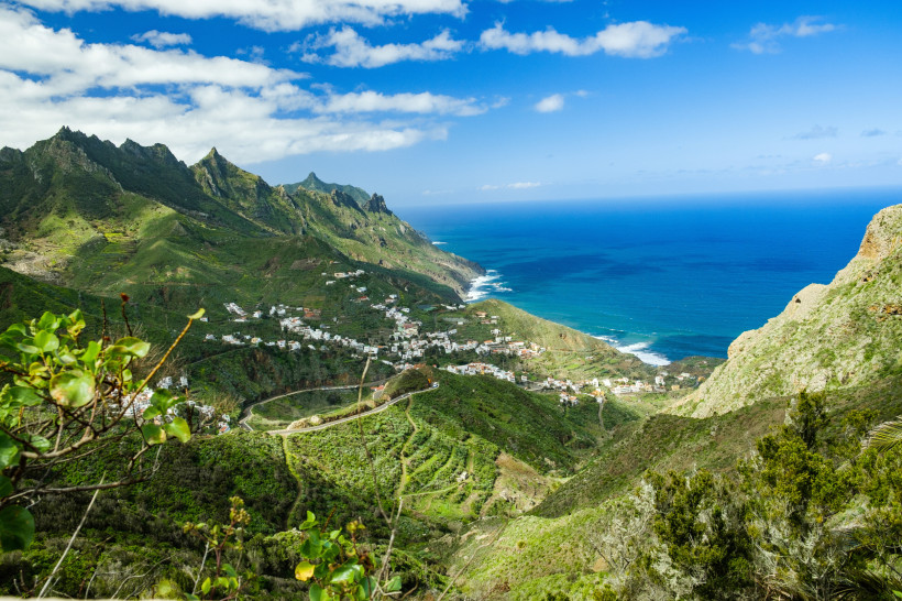 Teneriffa: Bergkette über einem Küstenort mit Blick auf den Atlantik Berglandschaft auf Teneriffa mit Küstenort, Serpentinenstraße und Blick auf den Atlantik