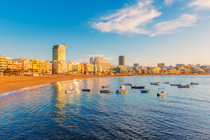 Playa de Las Canteras mit Stadtpromenade und vor Anker liegenden Booten im ruhigen Meer